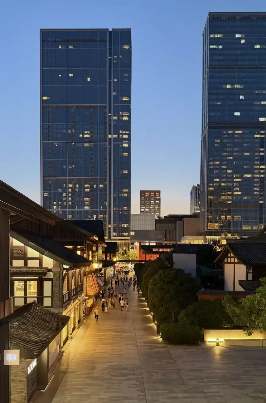 Taikoo Li pedestrian lanes beneath modern towers at dusk